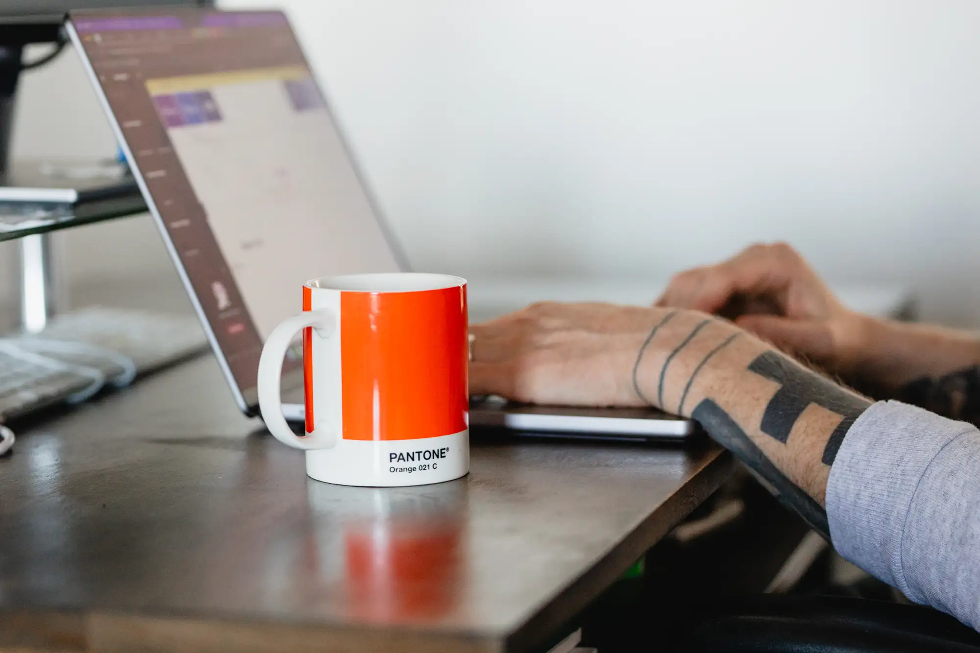 working on a laptop with coffee mug at a graphic design studio